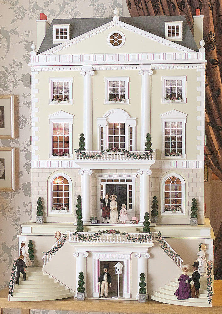 Detailed model of a large house with people on the steps and in the windows.
miniature dolls house 