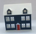 A miniature two-story house figurine with a dark navy blue body, a white roof, a red front door, and white-framed windows, set against a plain white background.