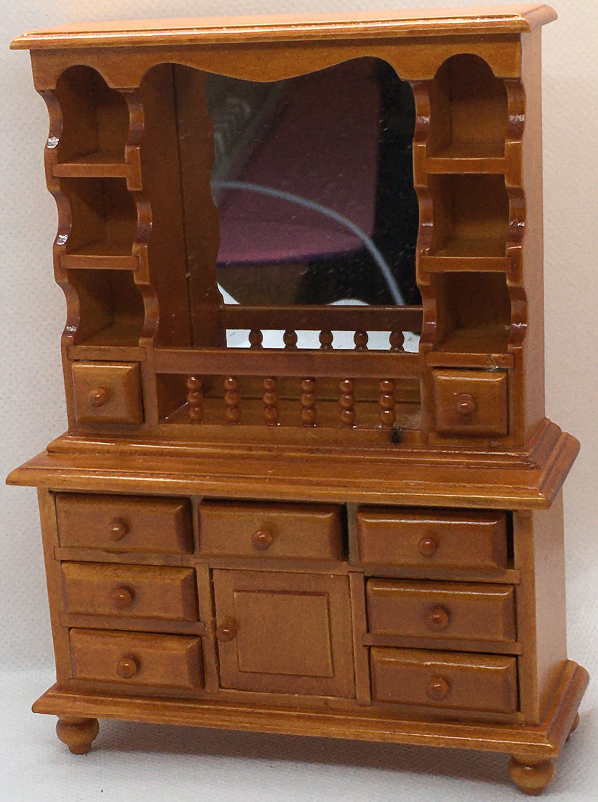 brown wooden miniature dresser with back mirror and opening drawers and cupboards on a white background