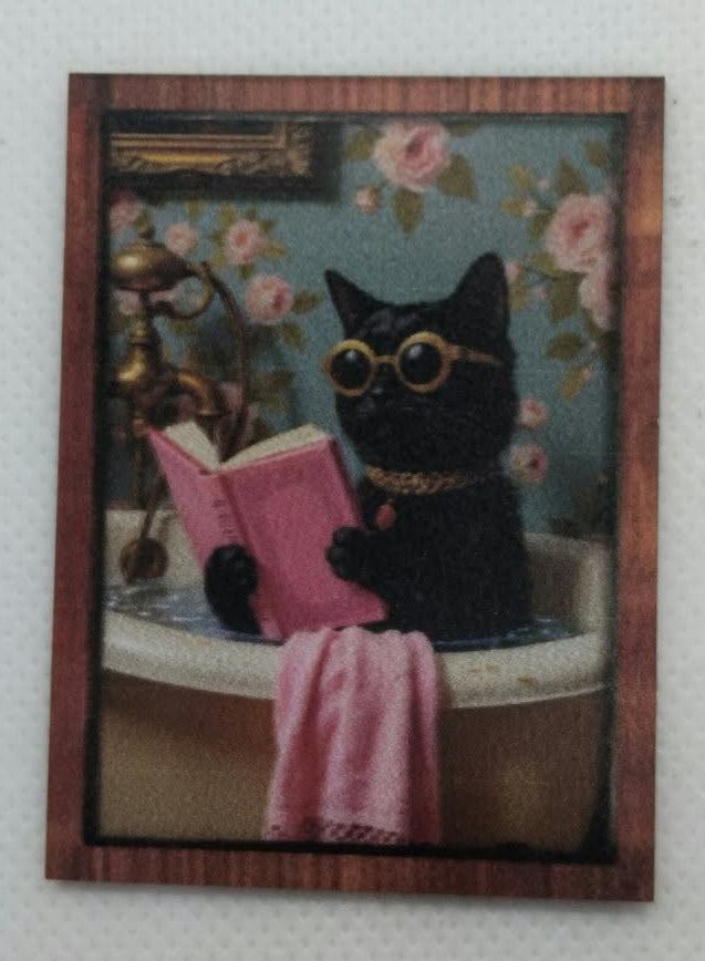 miniature picture of a black cat in a bath reading a book with a pink towel over the bath, on a white background