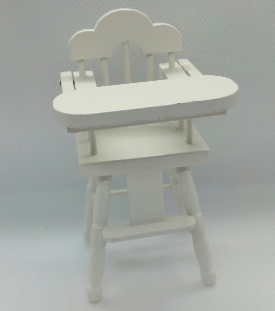 A miniature white wooden dollhouse high chair with a cloud-shaped backrest and a flat tray, shown on a light gray textured background.