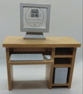 A miniature wooden computer desk with a monitor, keyboard, mouse, and storage compartments, shown on a plain white background.